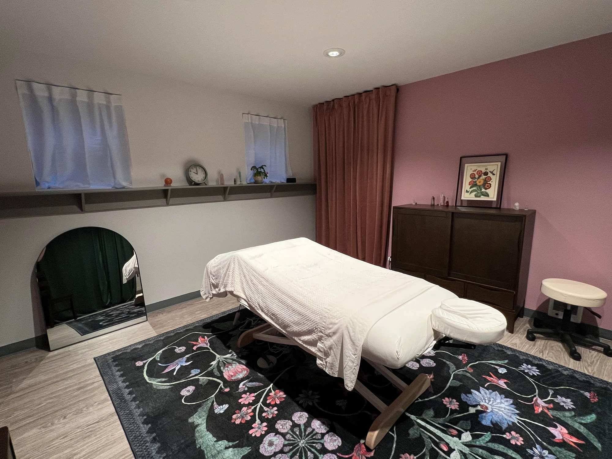A closer view of the massage table, soft linens and rose-toned treatment room